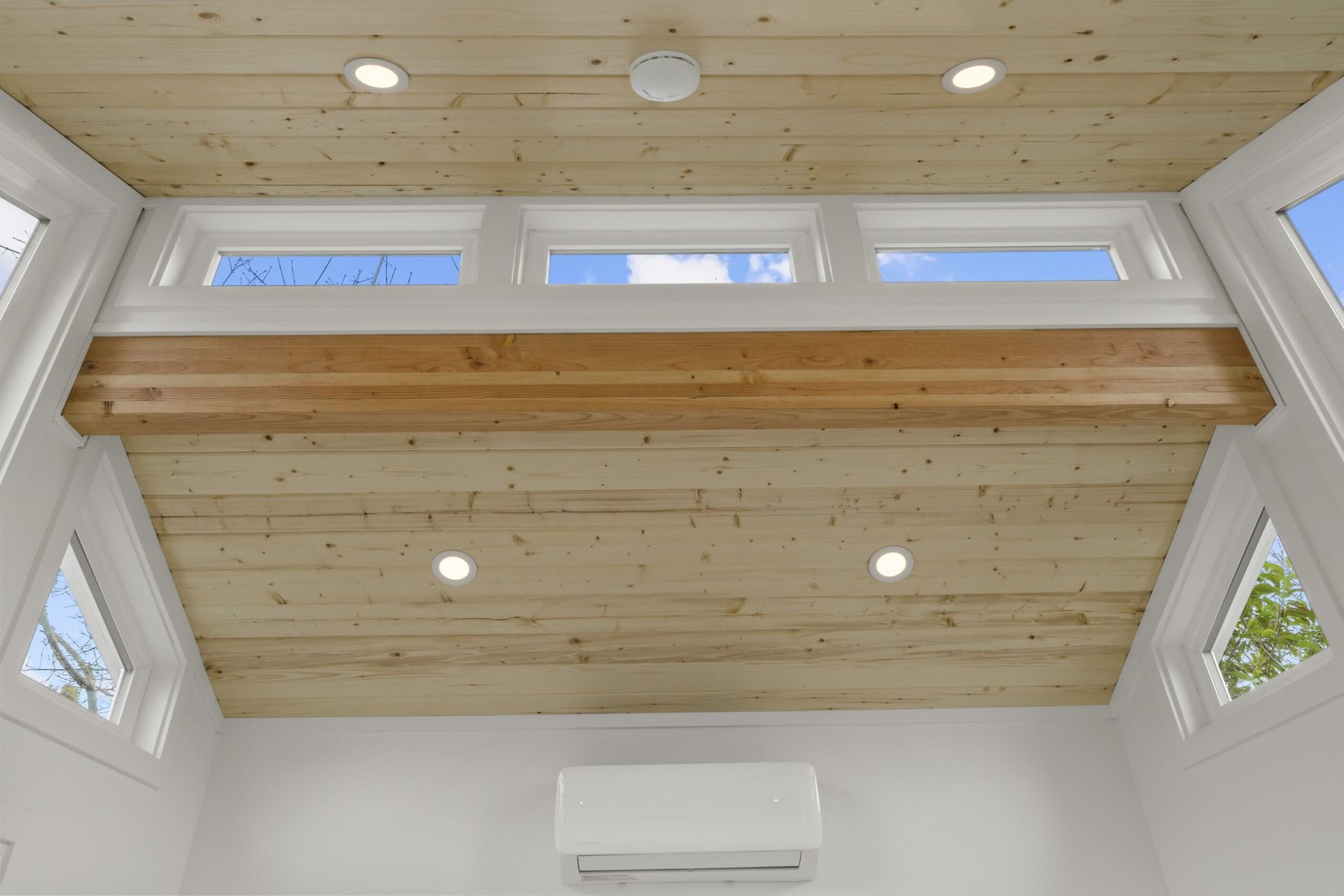 A room with a wooden ceiling and lots of windows.