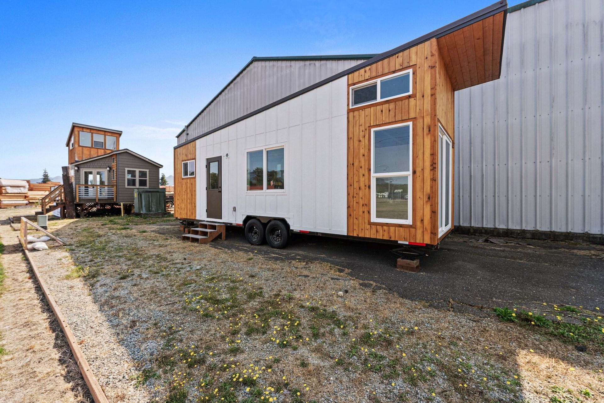 A tiny house is parked in front of a building.