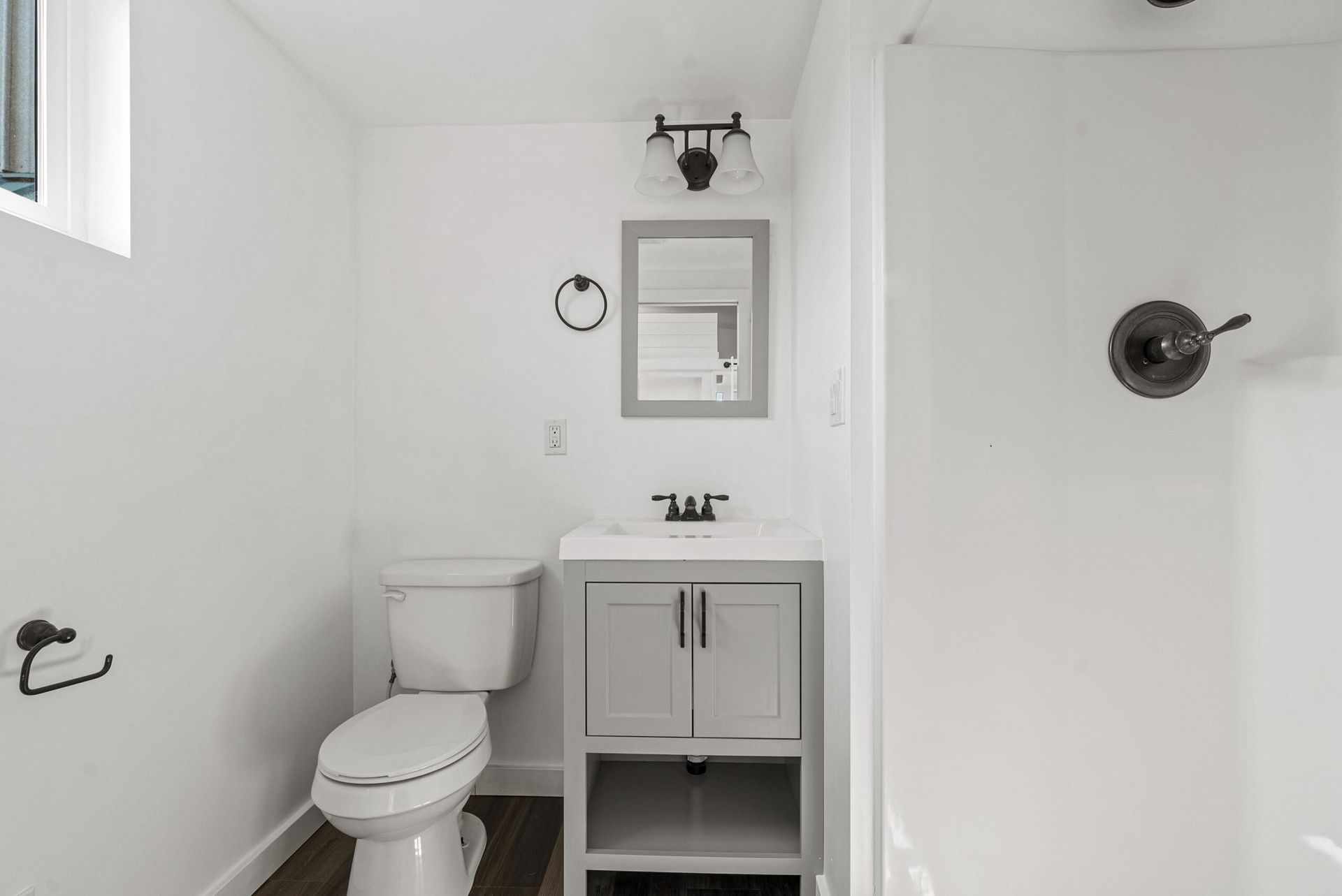 A bathroom with a toilet, sink and shower.