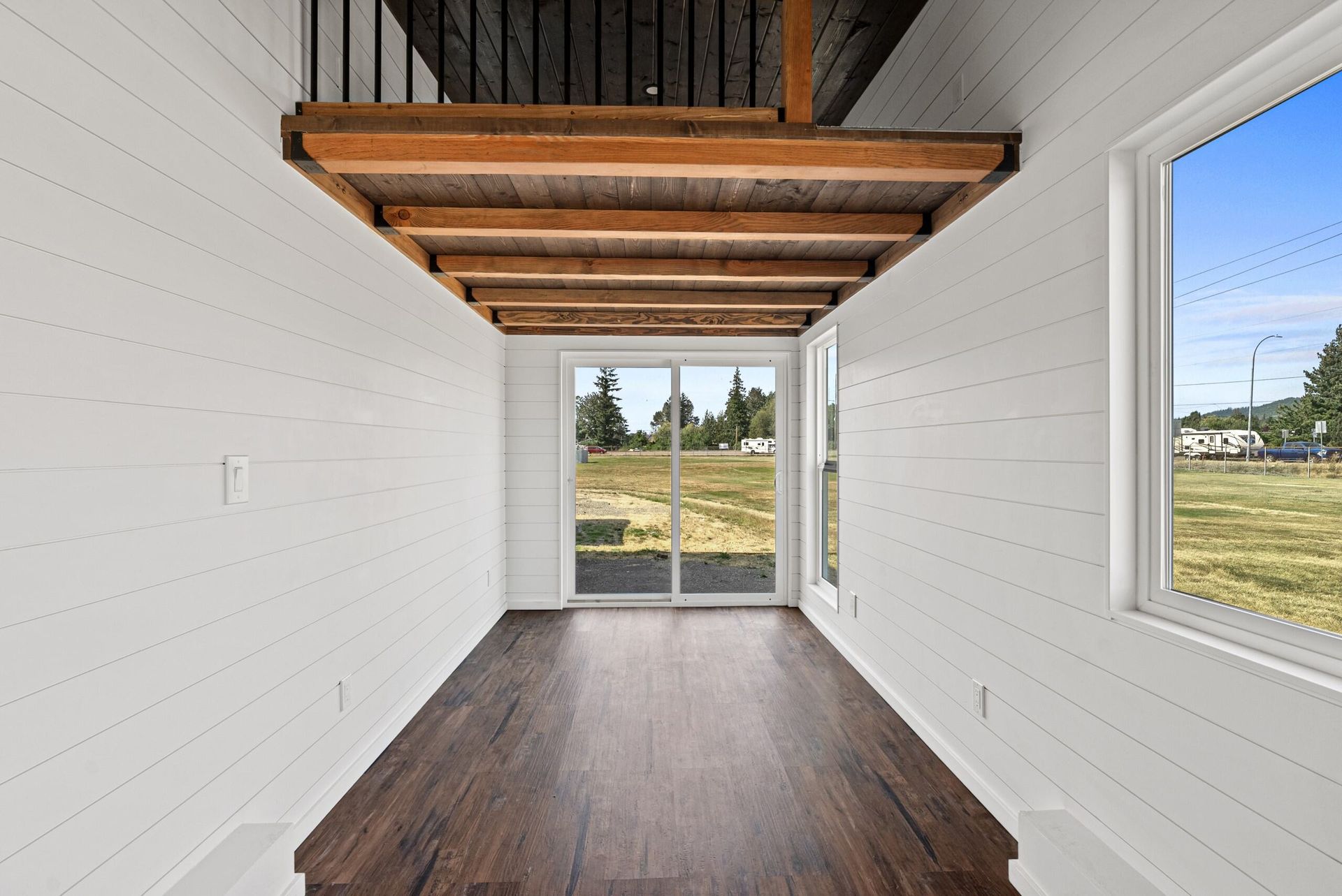 An empty room with hardwood floors and white walls.