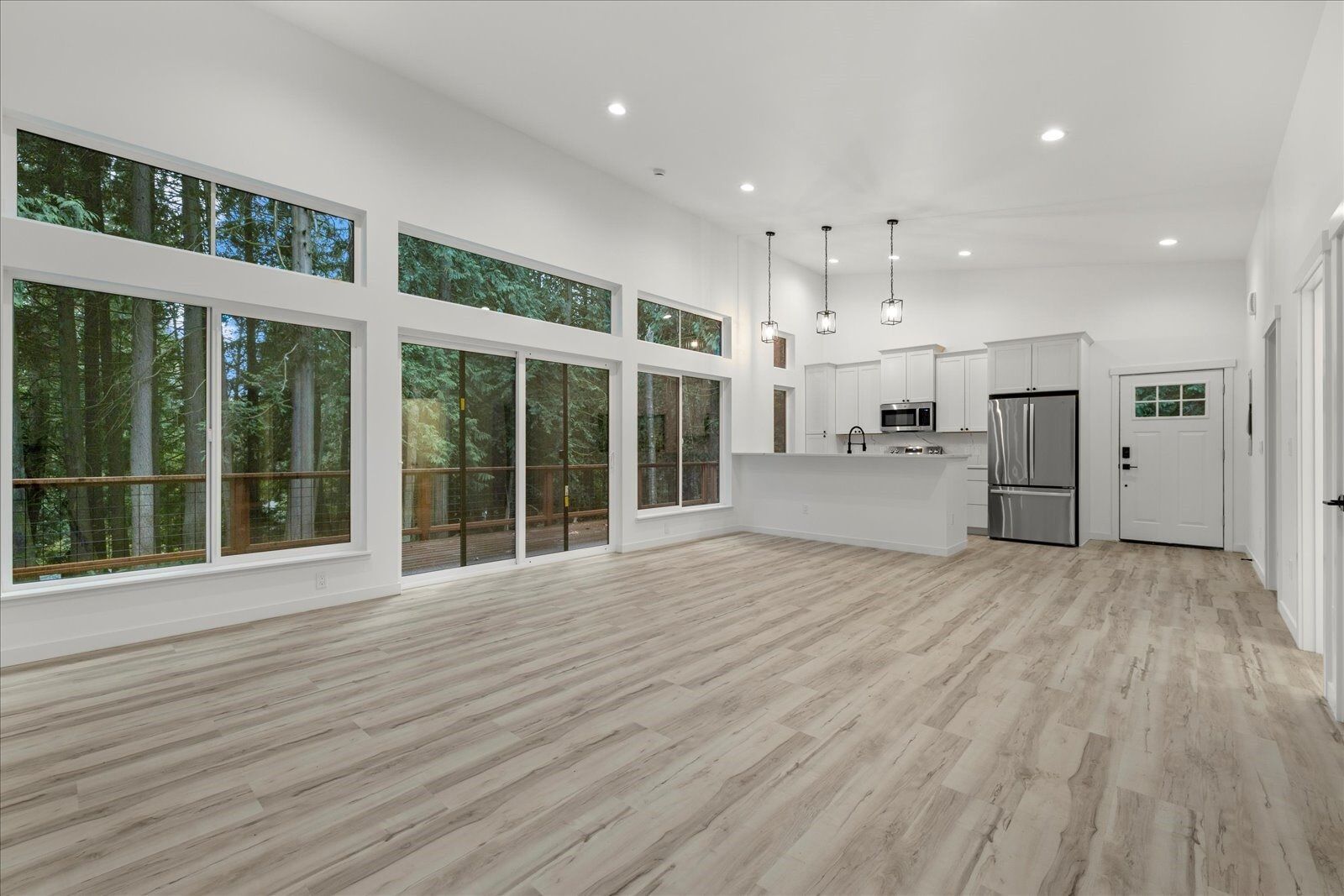 A large empty room with hardwood floors and lots of windows.