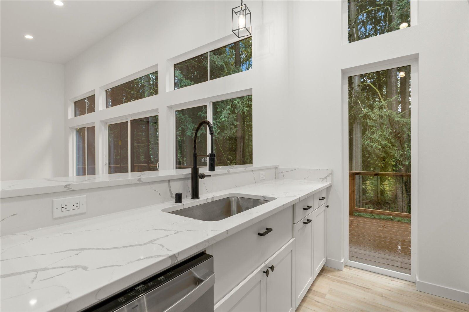A kitchen with a sink, dishwasher, and stainless steel appliances.