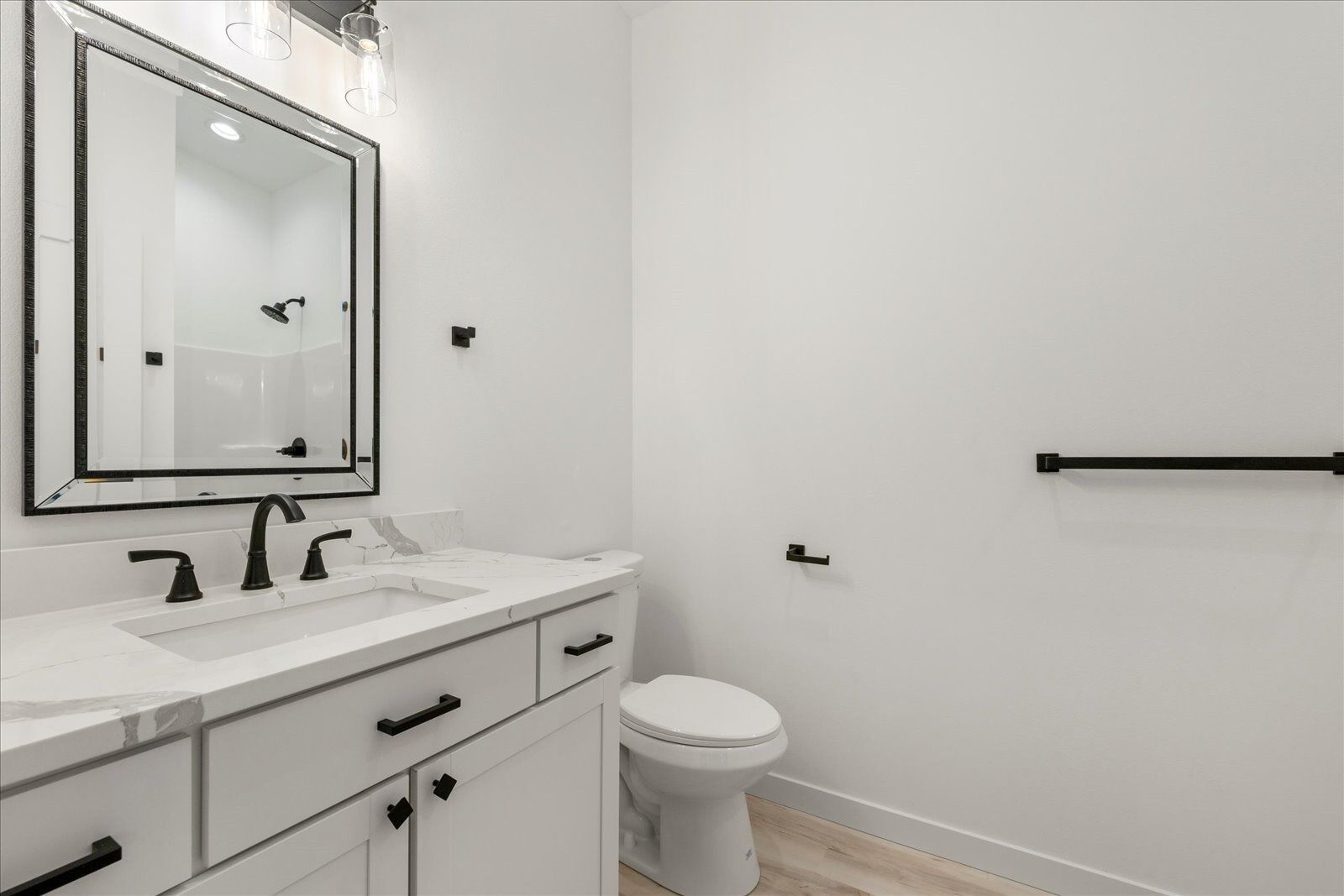 A bathroom with a sink, toilet and mirror.
