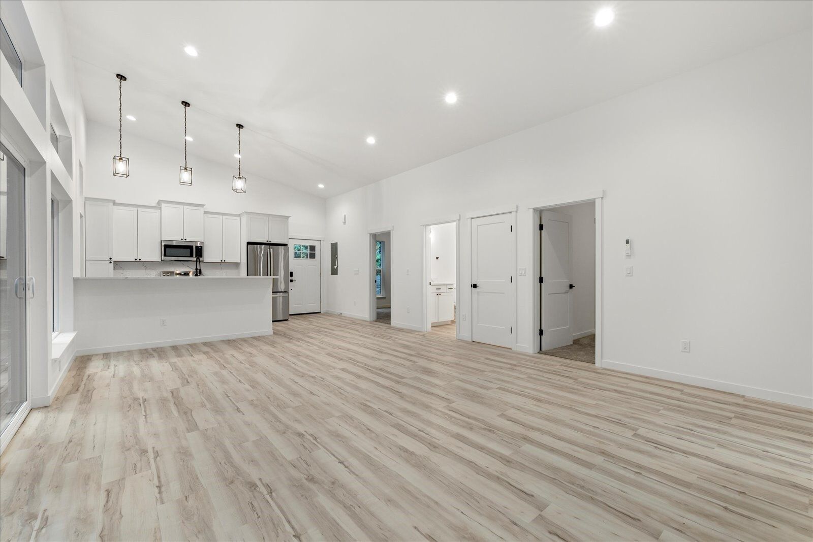A large empty room with hardwood floors and white walls.