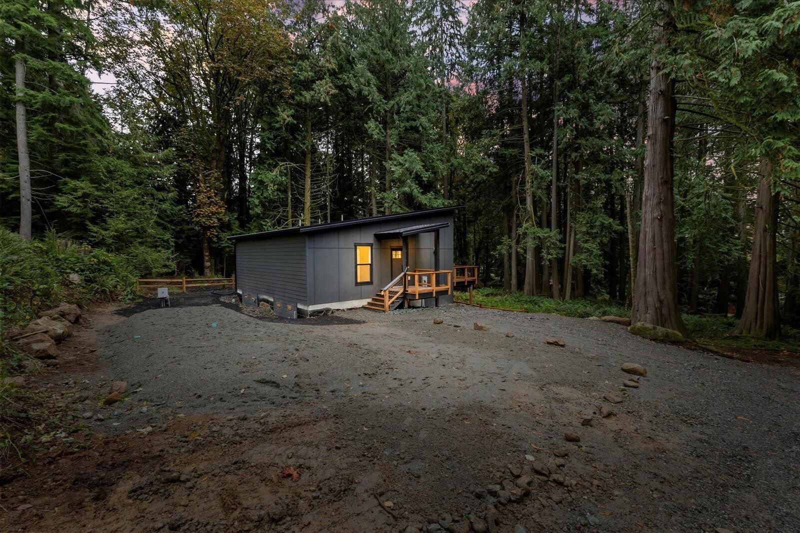 A small house is sitting in the middle of a forest.