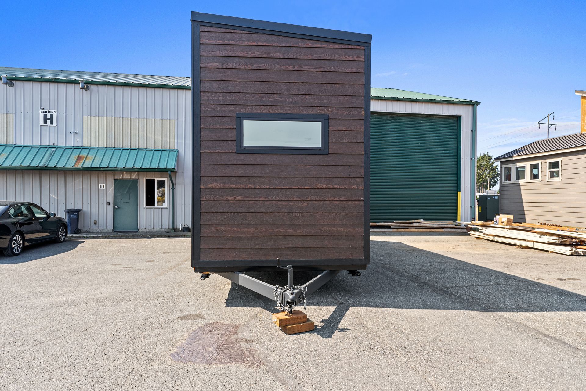 A small trailer is parked in front of a building.