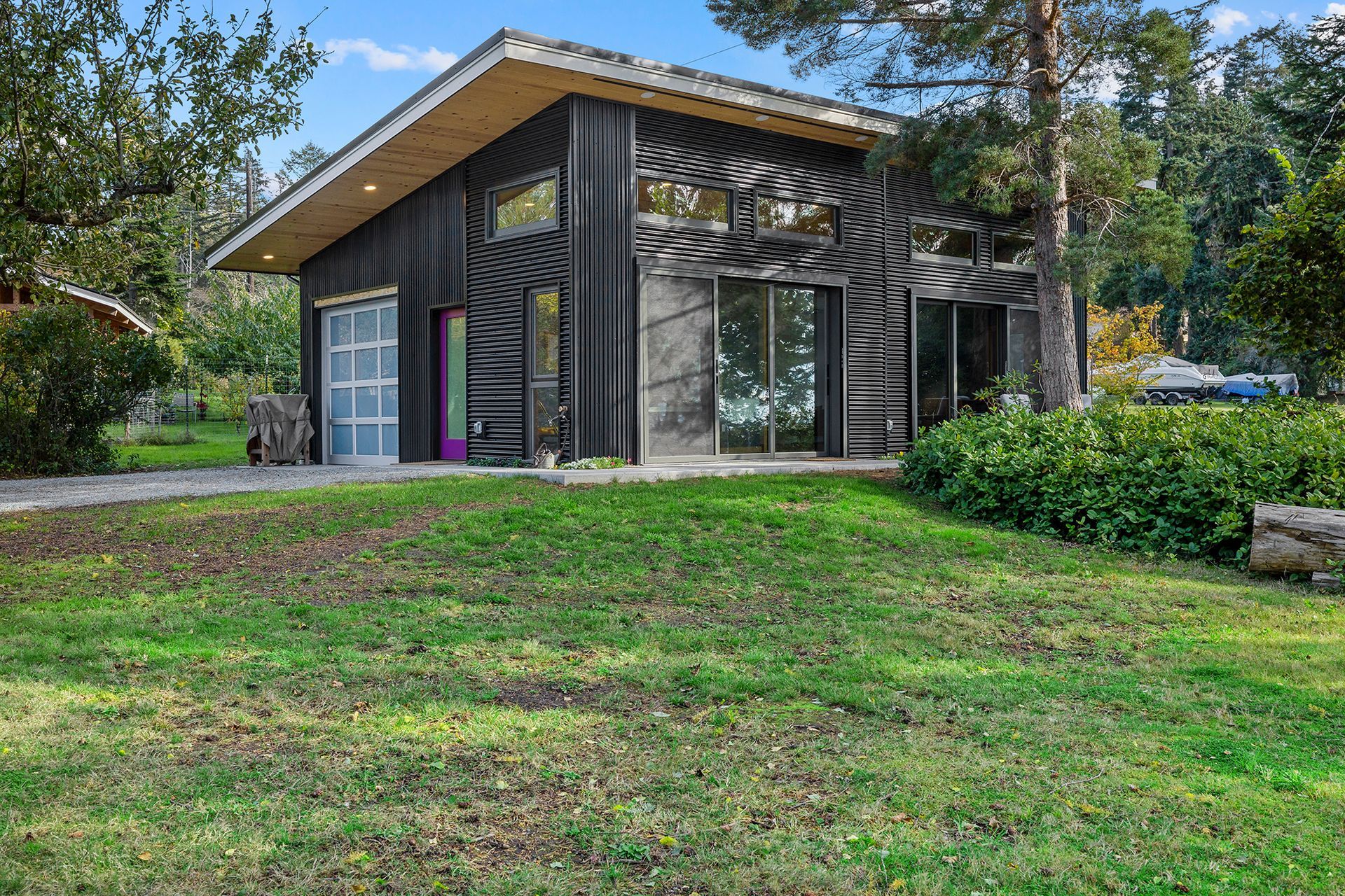 A small house is sitting on top of a lush green hill.