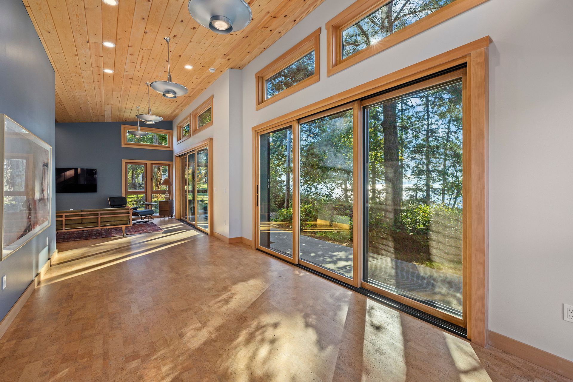 A living room with a lot of windows and sliding glass doors.