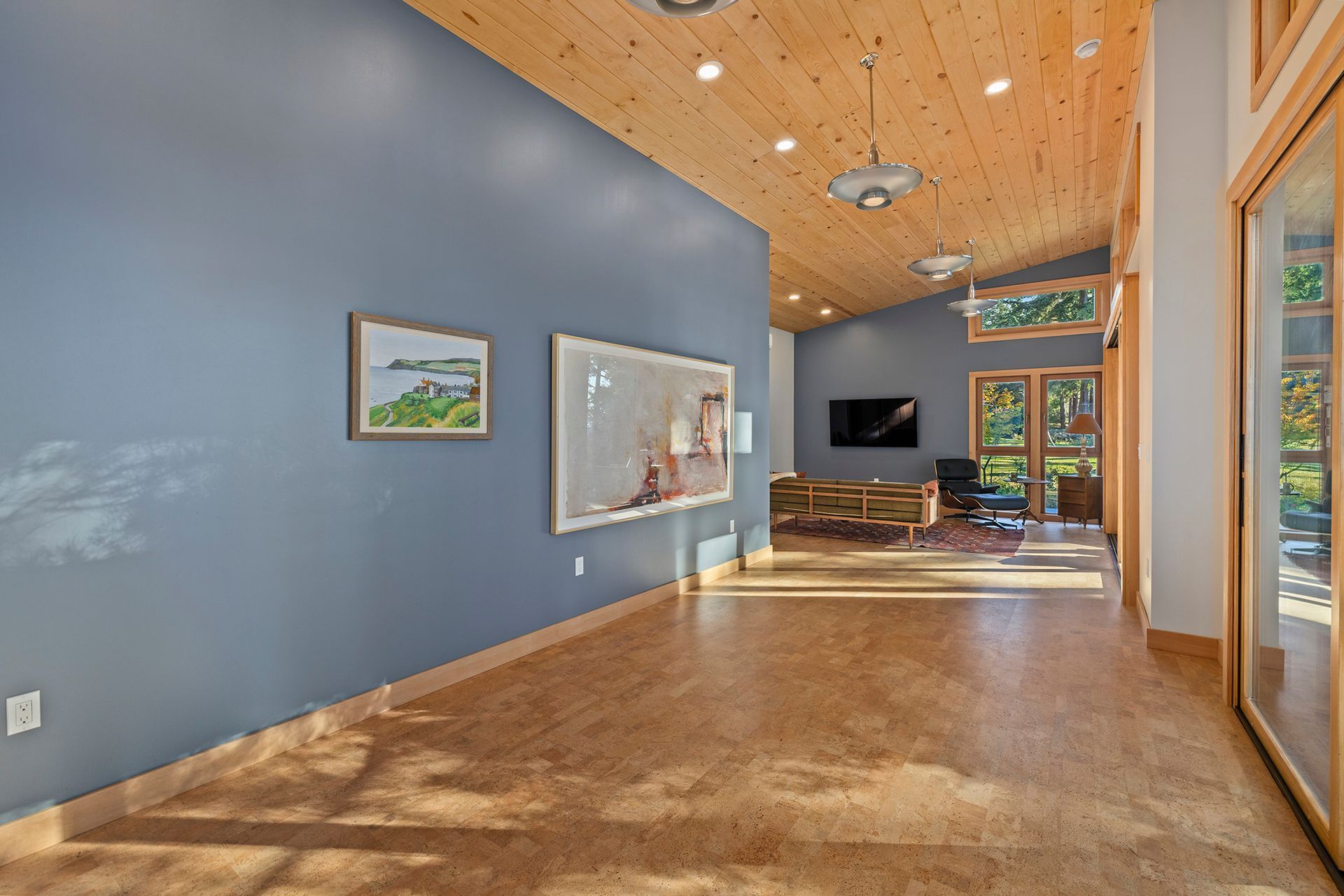 A living room with blue walls and a wooden floor.