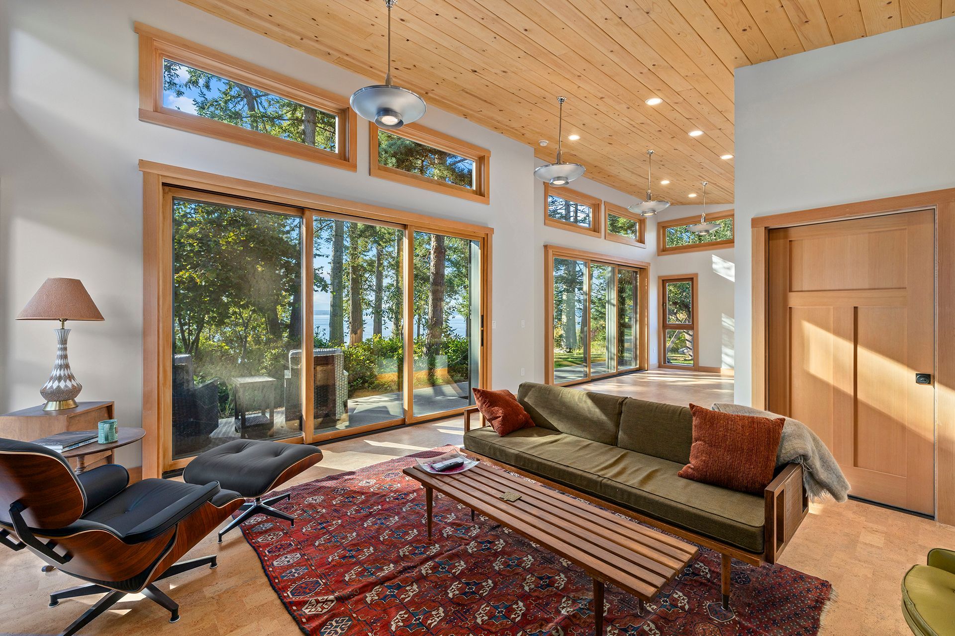 A living room with a couch, chair, coffee table, and sliding glass doors.