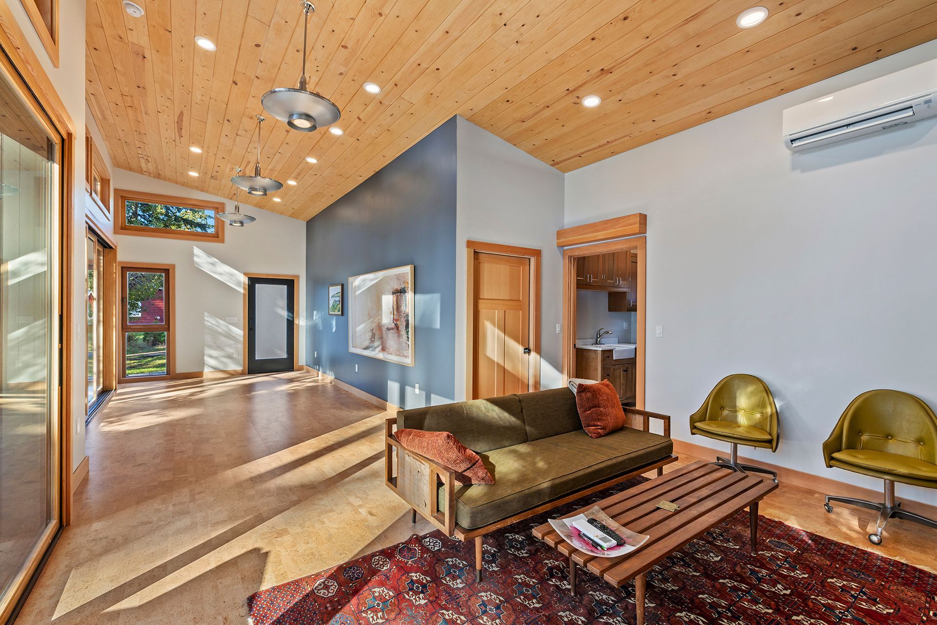 A living room with a couch, table, chairs, and a rug.
