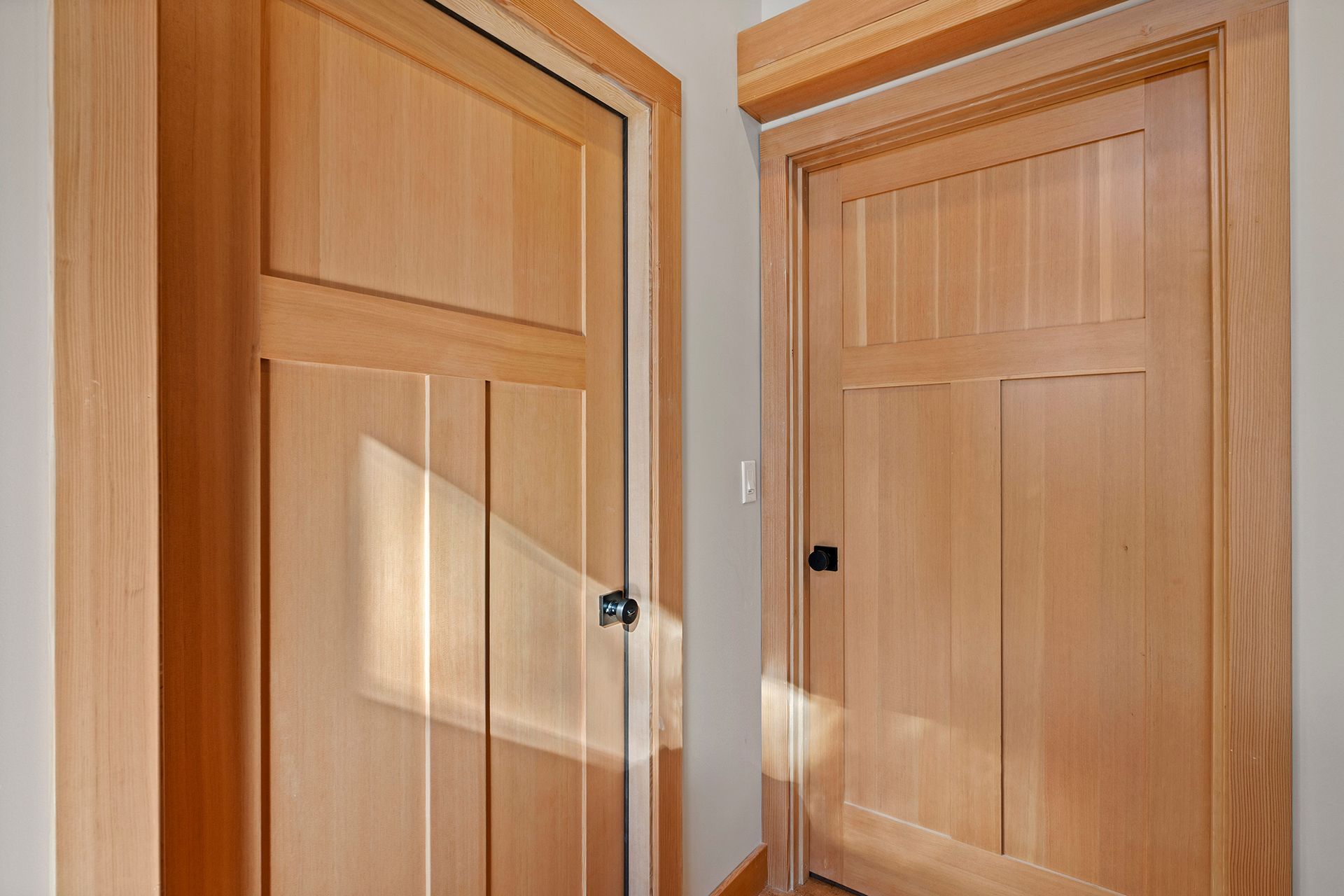 Two wooden doors are sitting next to each other in a room.