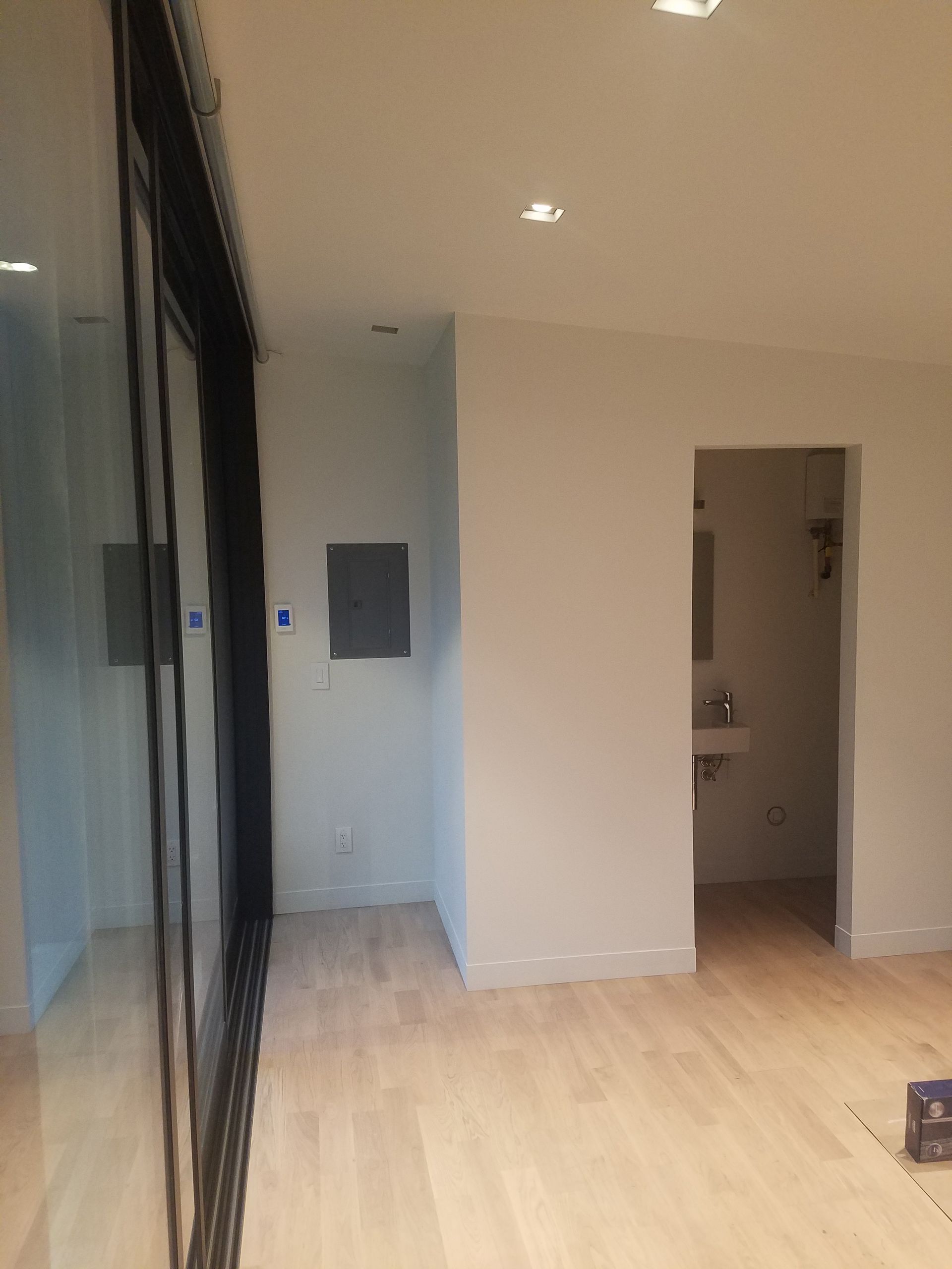 An empty room with hardwood floors and white walls.