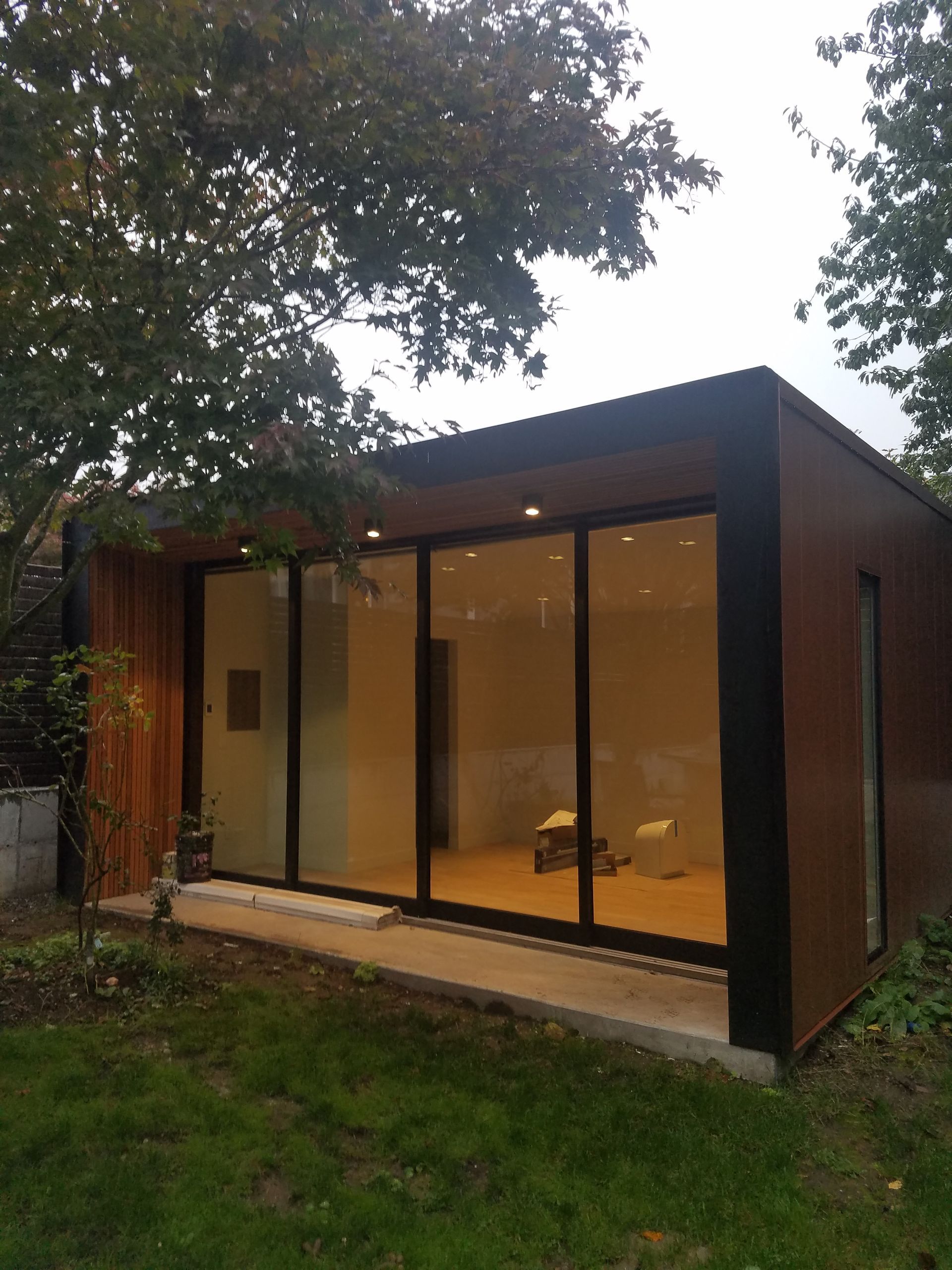 A house with a lot of windows and a tree in front of it