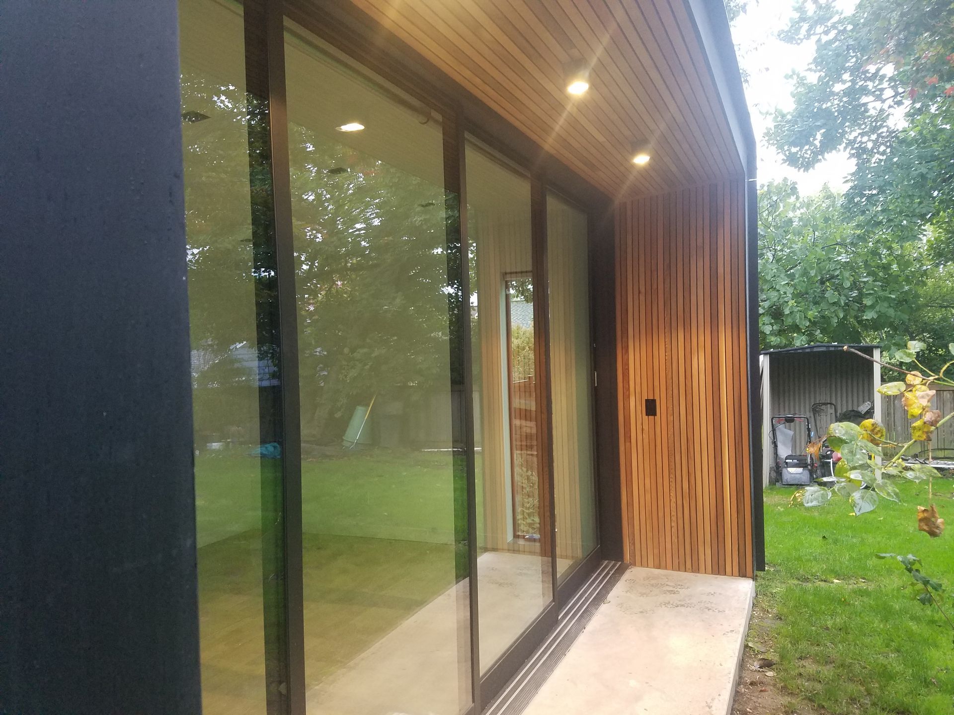 A house with a lot of windows and trees in the background