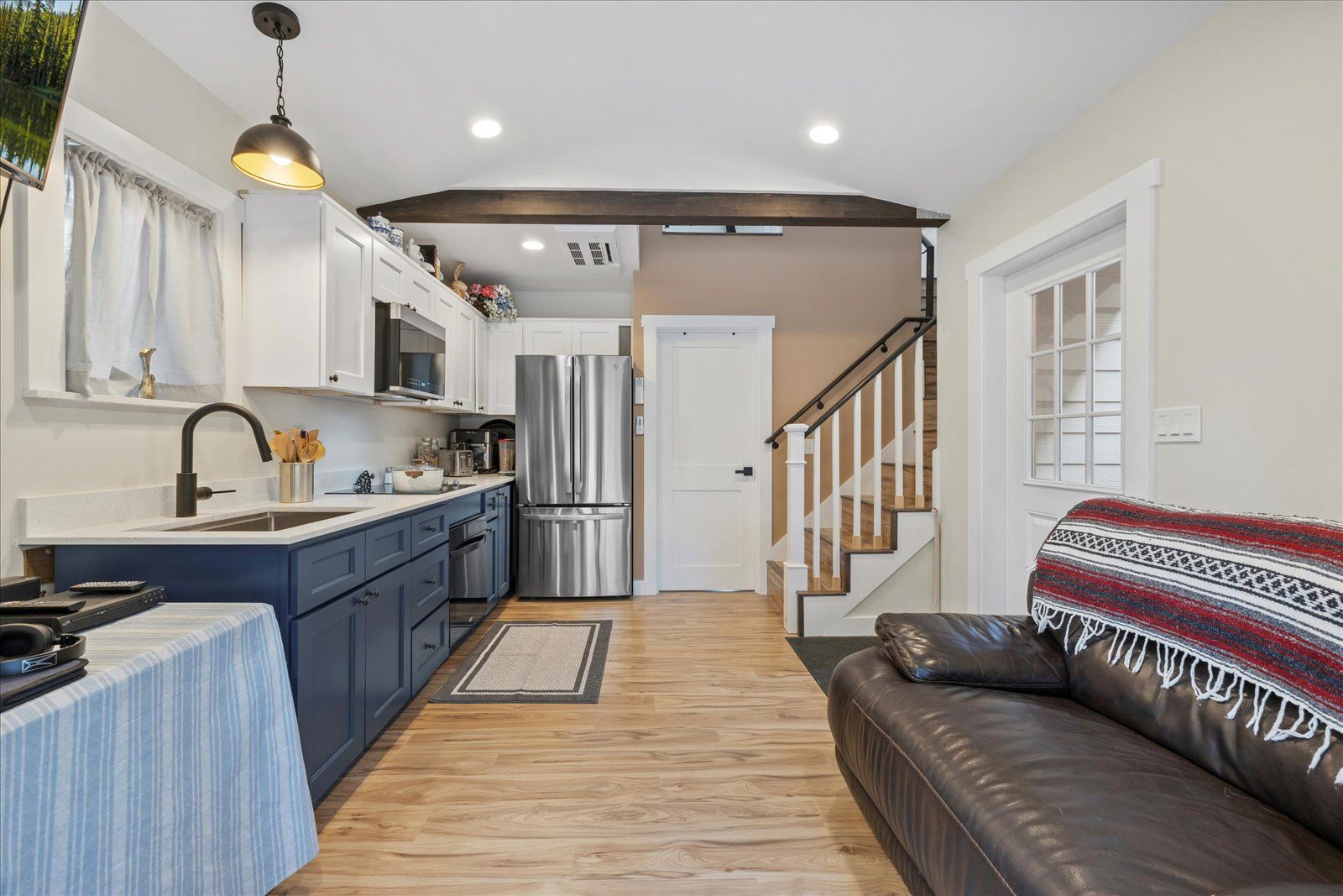 There is a couch in the living room next to the kitchen.