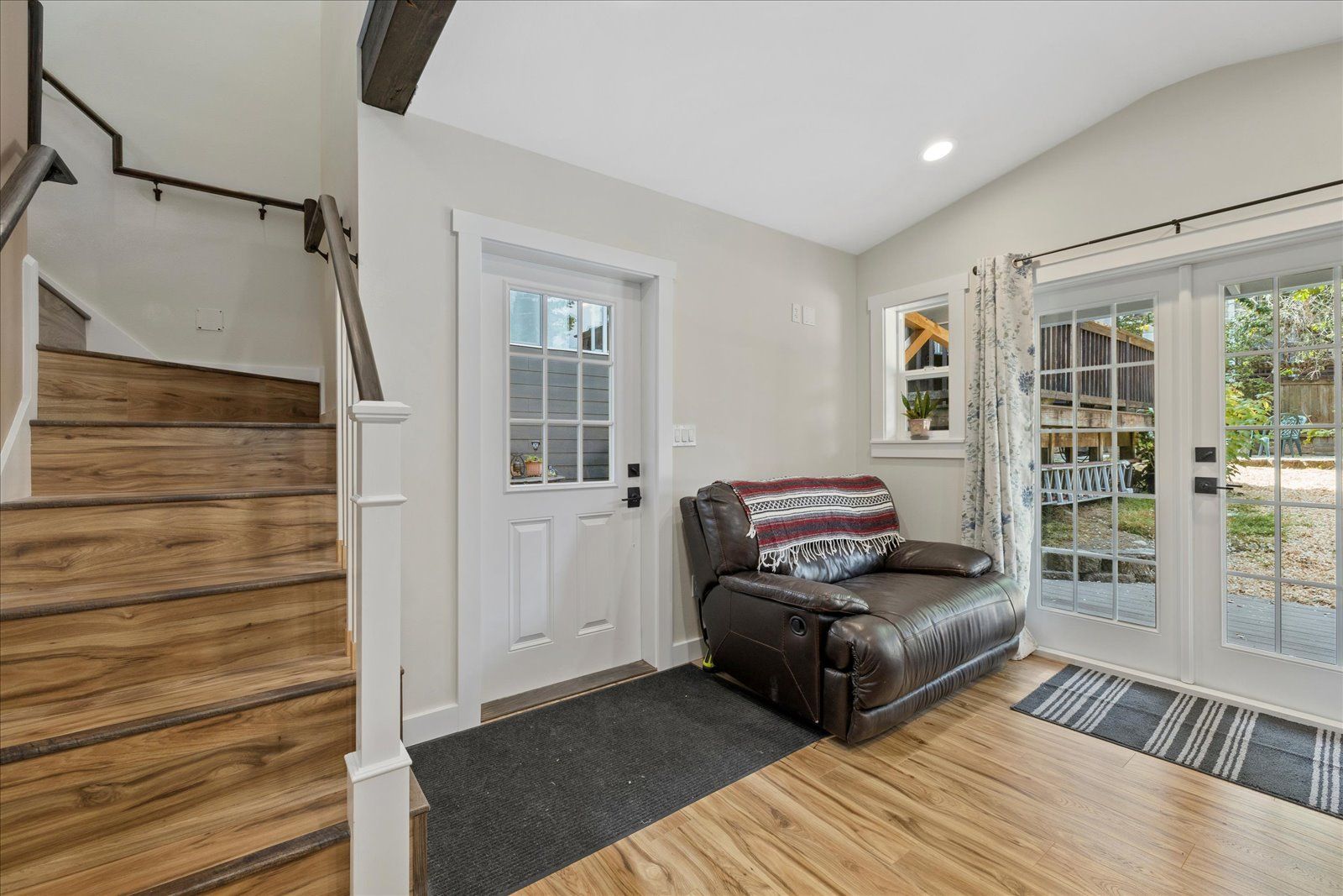 A living room with a couch and stairs leading up to the second floor.