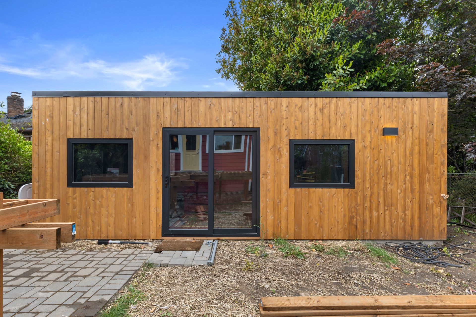 A wooden house with a lot of windows and a sliding glass door.