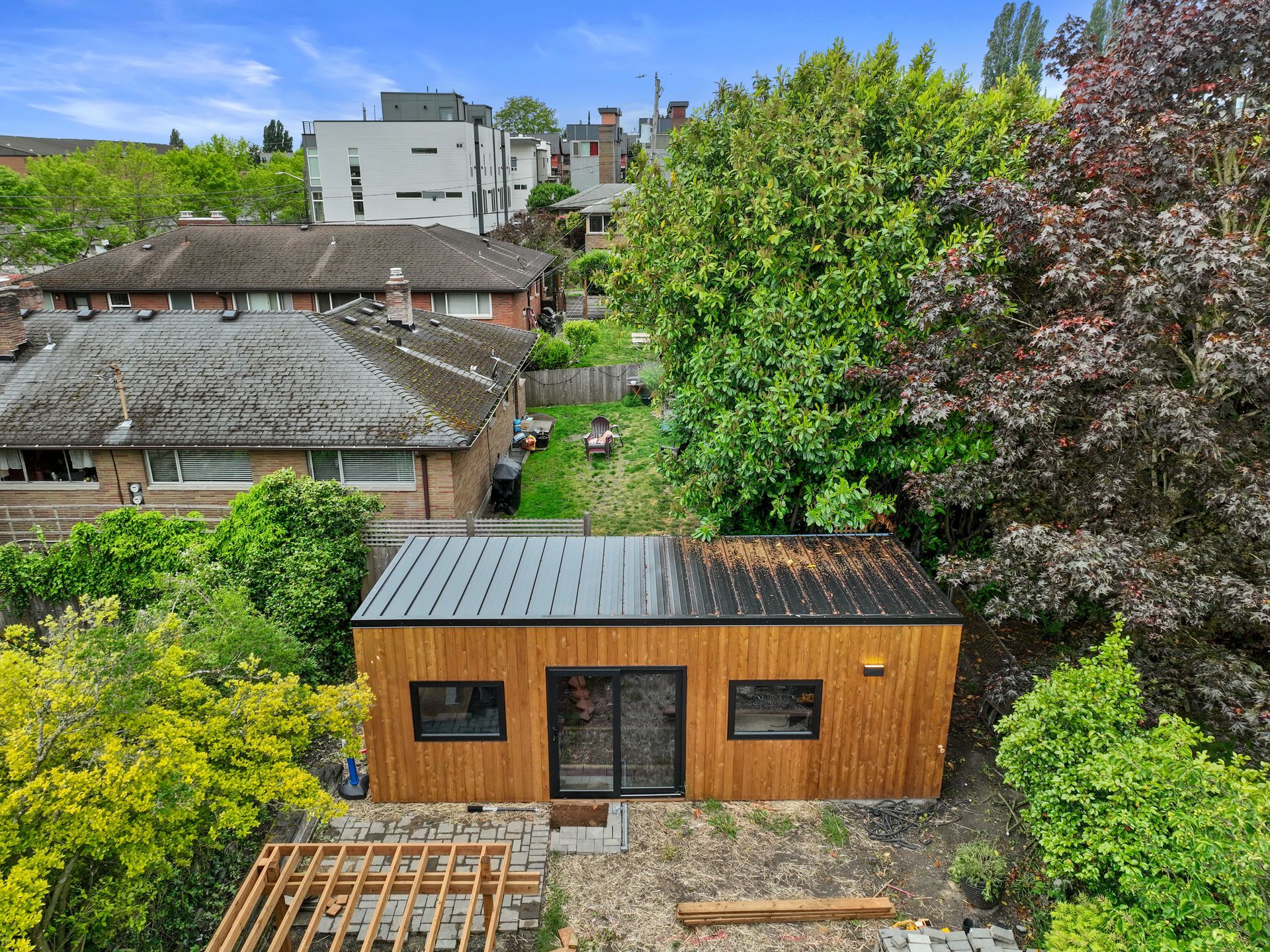 An aerial view of a small wooden house surrounded by trees.