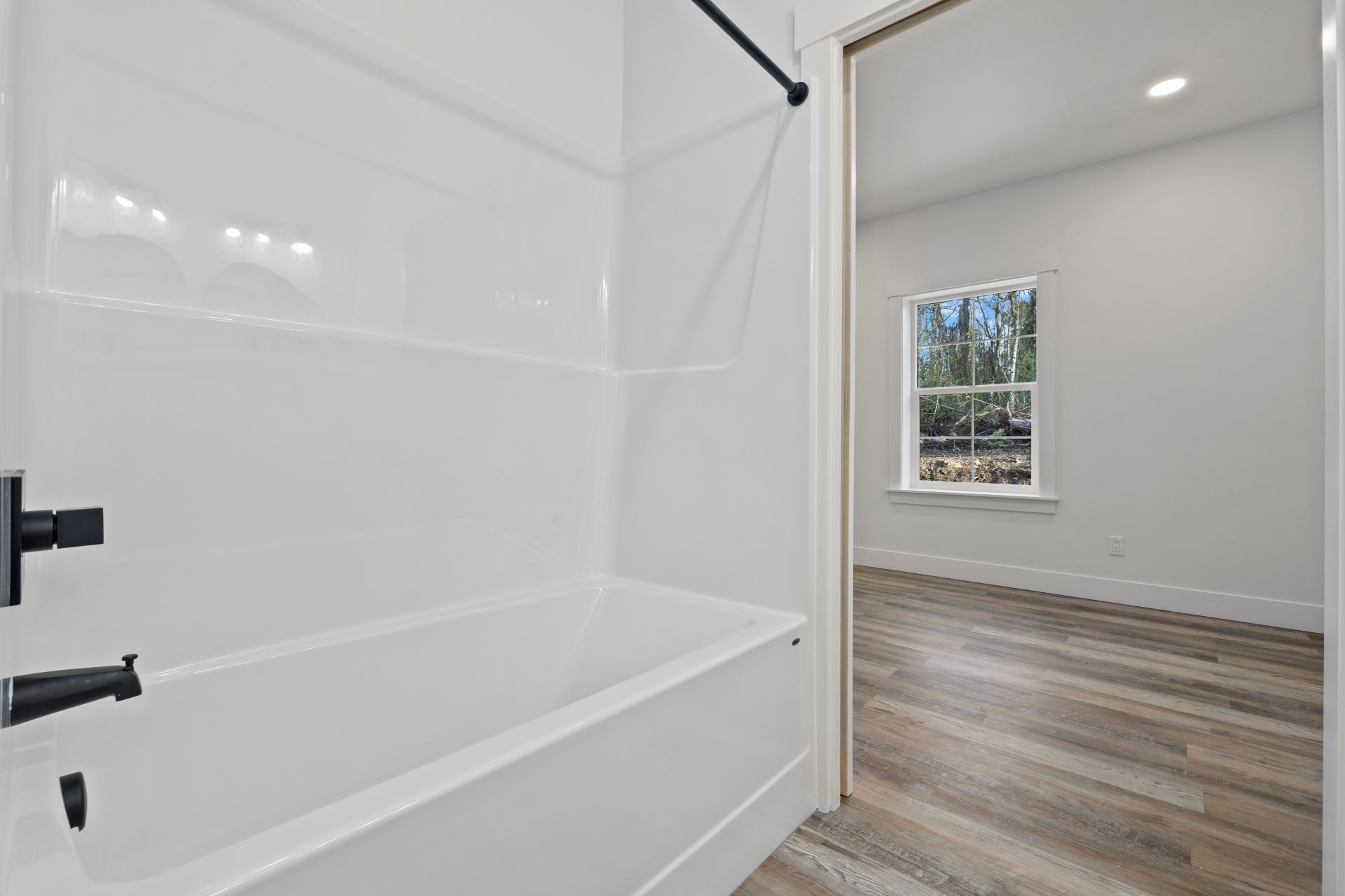 A bathroom with a bathtub and a window.