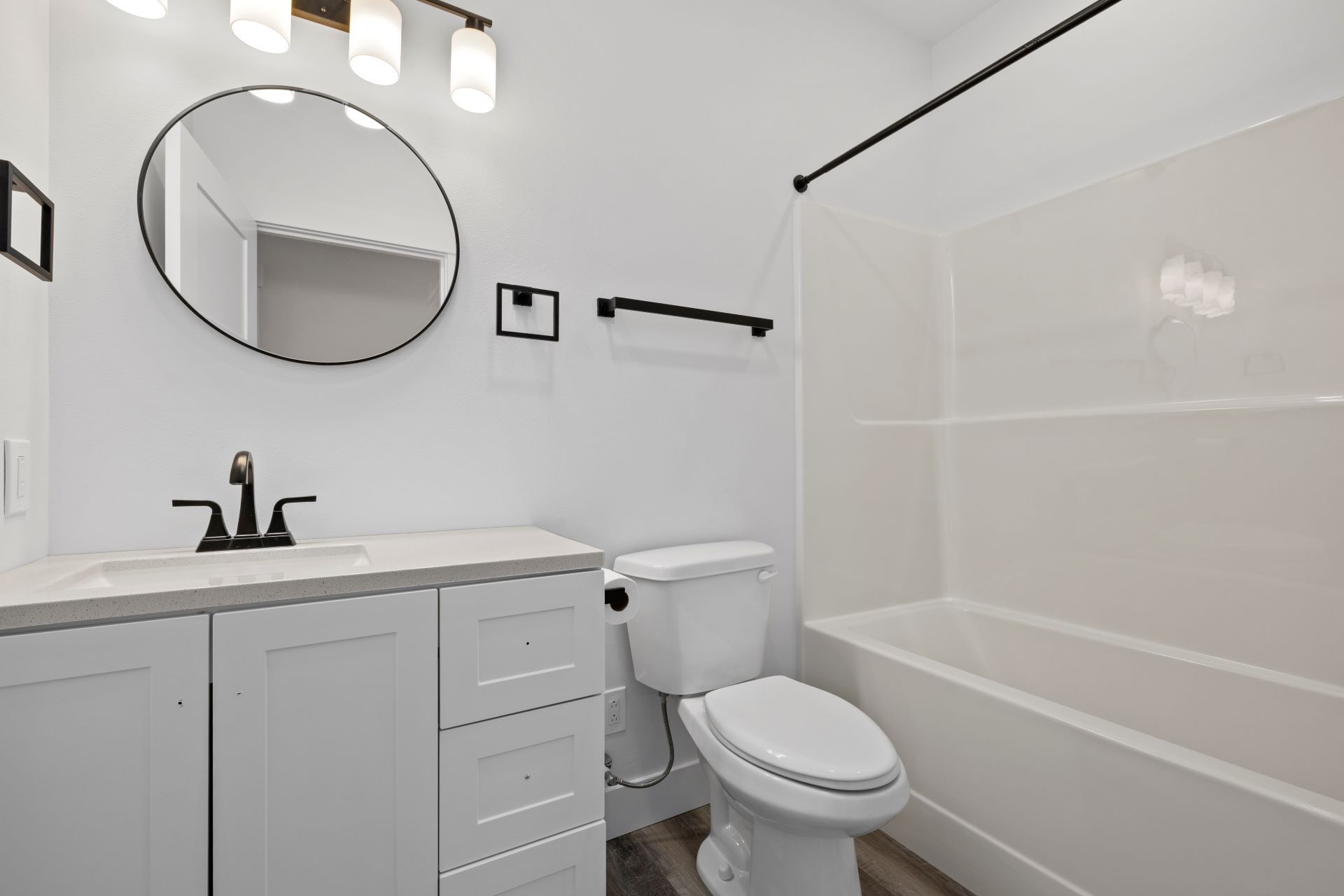 A bathroom with a toilet , sink , mirror and bathtub.