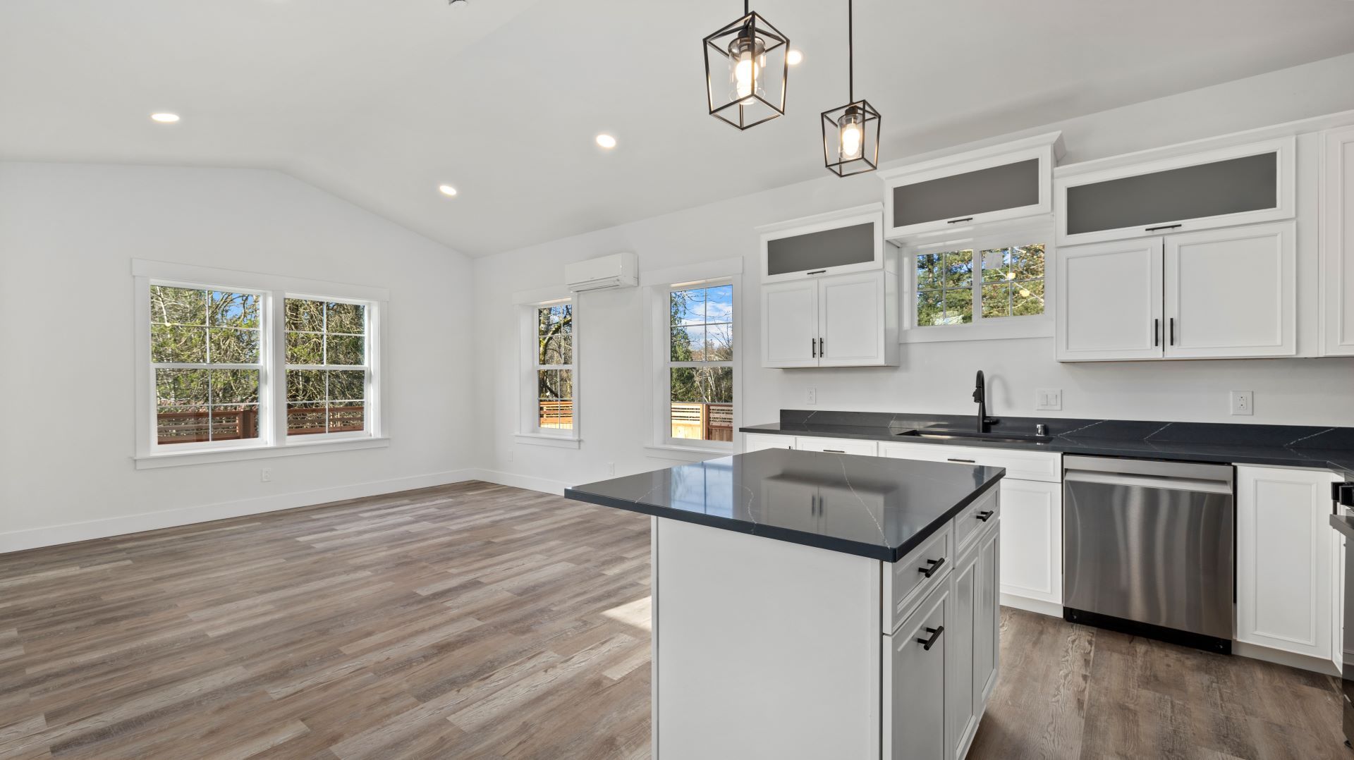 An empty kitchen with white cabinets and stainless steel appliances.