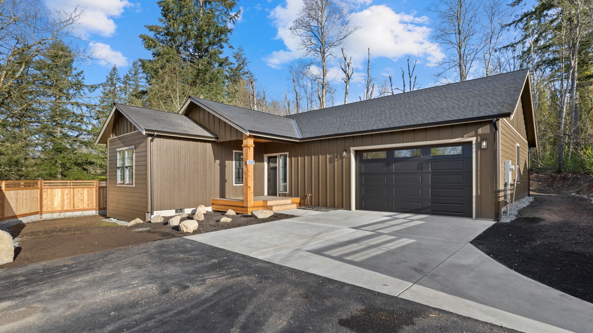 A house with a garage and a driveway in front of it.