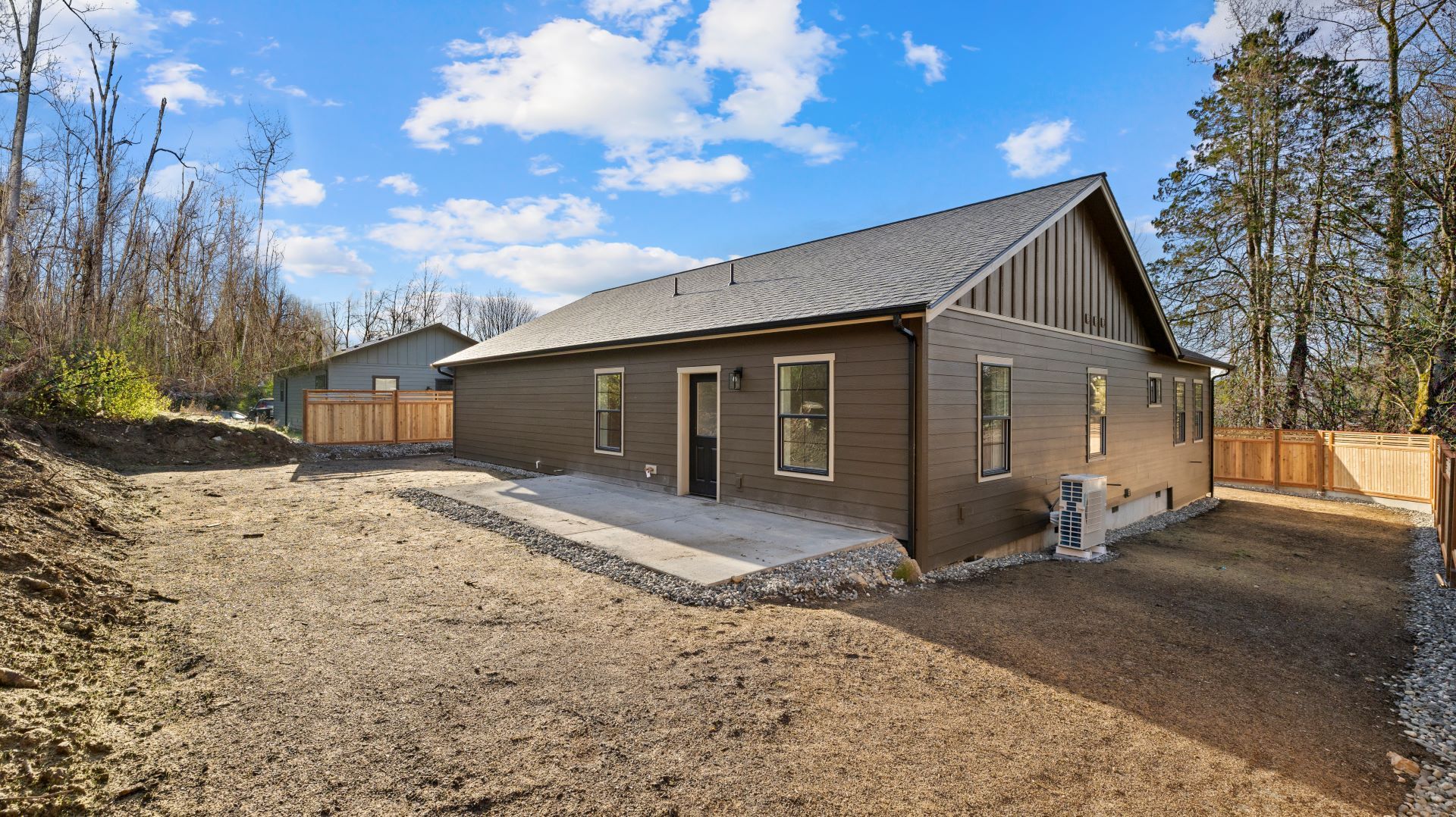 The back of a house with a lot of dirt in front of it.