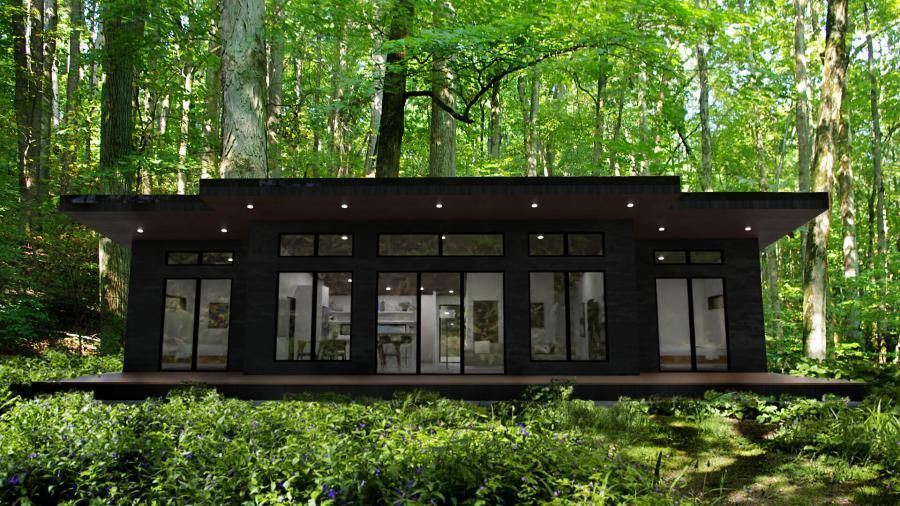 A small house is sitting in the middle of a forest.