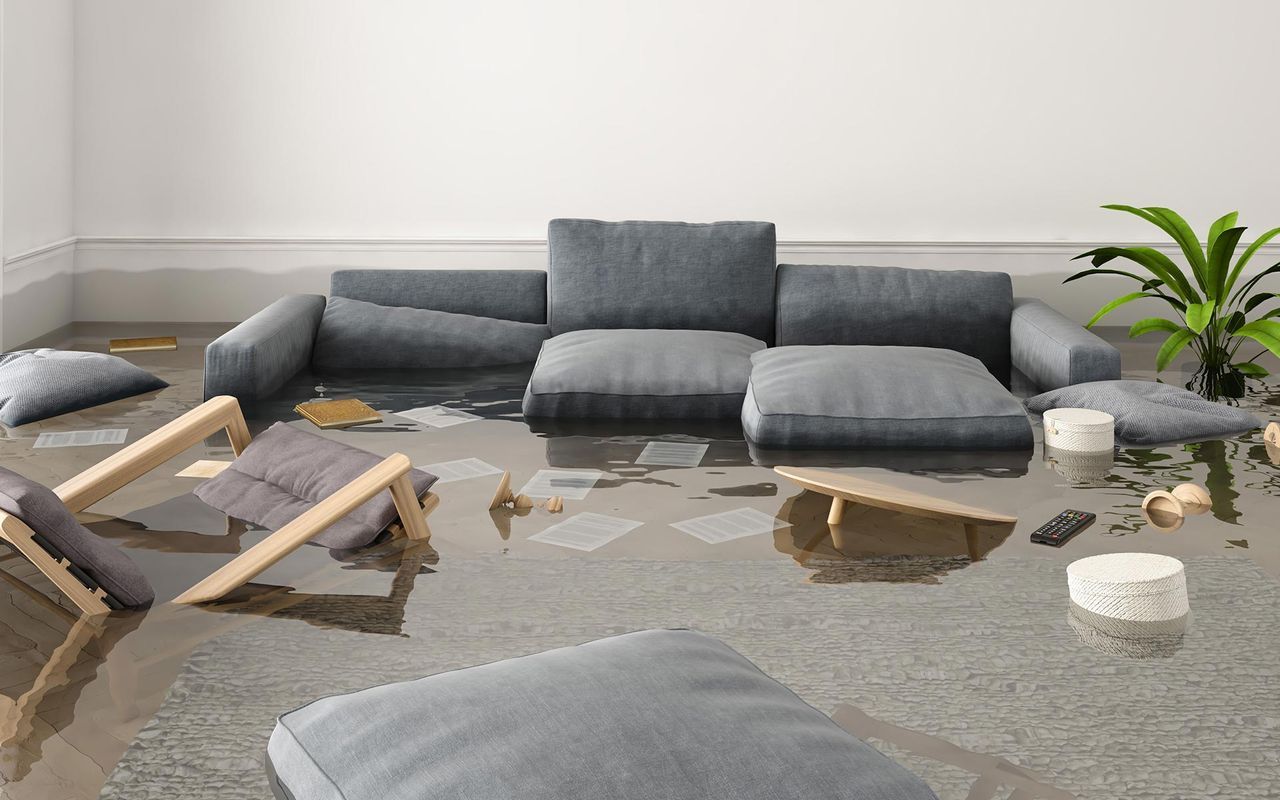 a living room with a couch and chairs covered in water