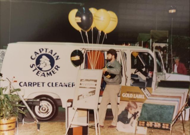 a man standing in front of a captain steamer carpet cleaner van