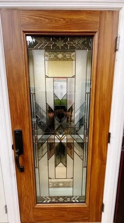 Wooden door with stained glass window, featuring geometric patterns and amber/clear glass.