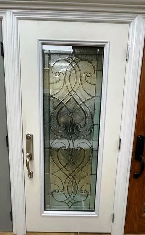 White exterior door with decorative glass panel and silver hardware.