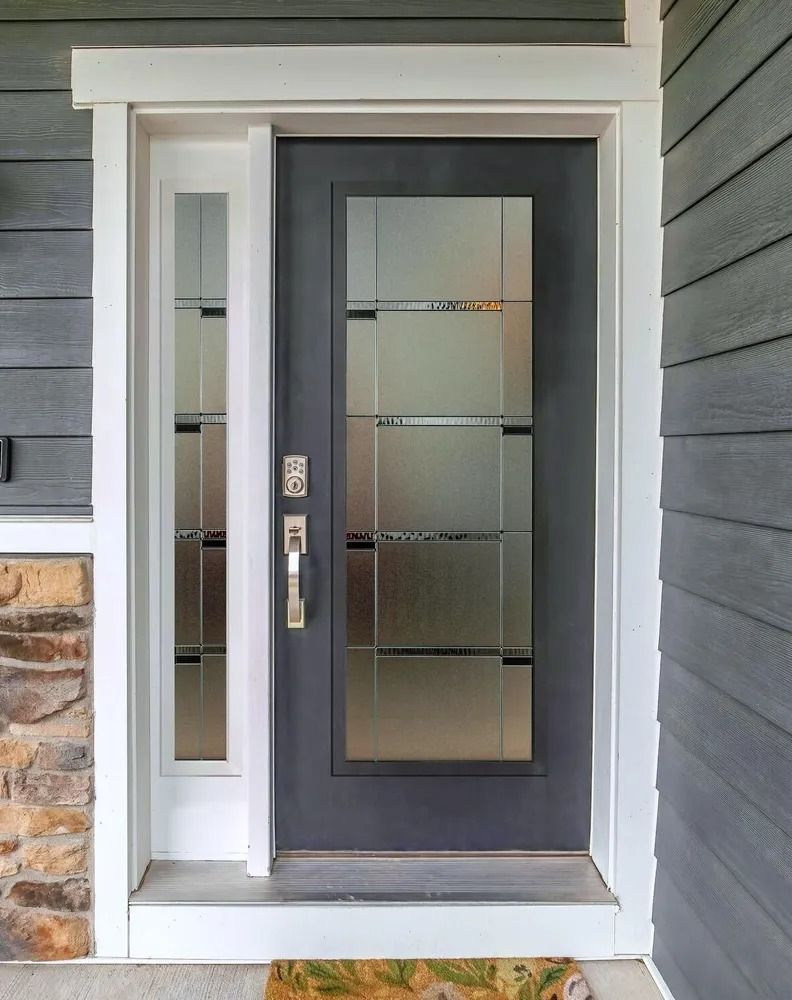 Gray front door with glass panels and sidelight, set in white trim.