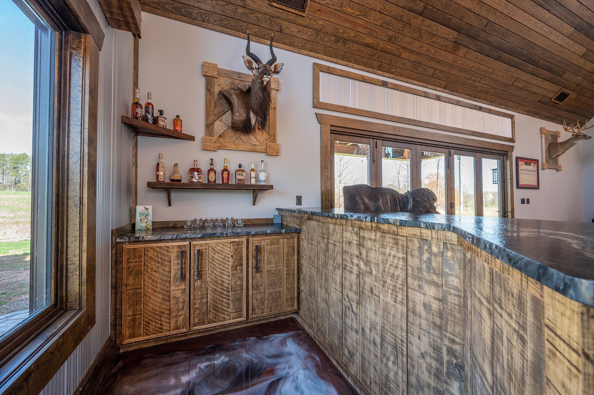 Stanley project - wooden bar with cabinets and shelves displaying alcoholic beverages