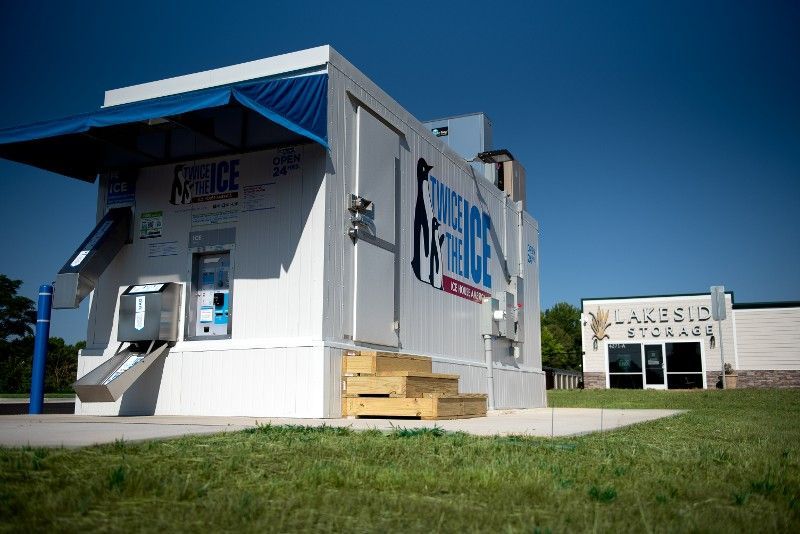 A white building with a blue awning is in front of a school.