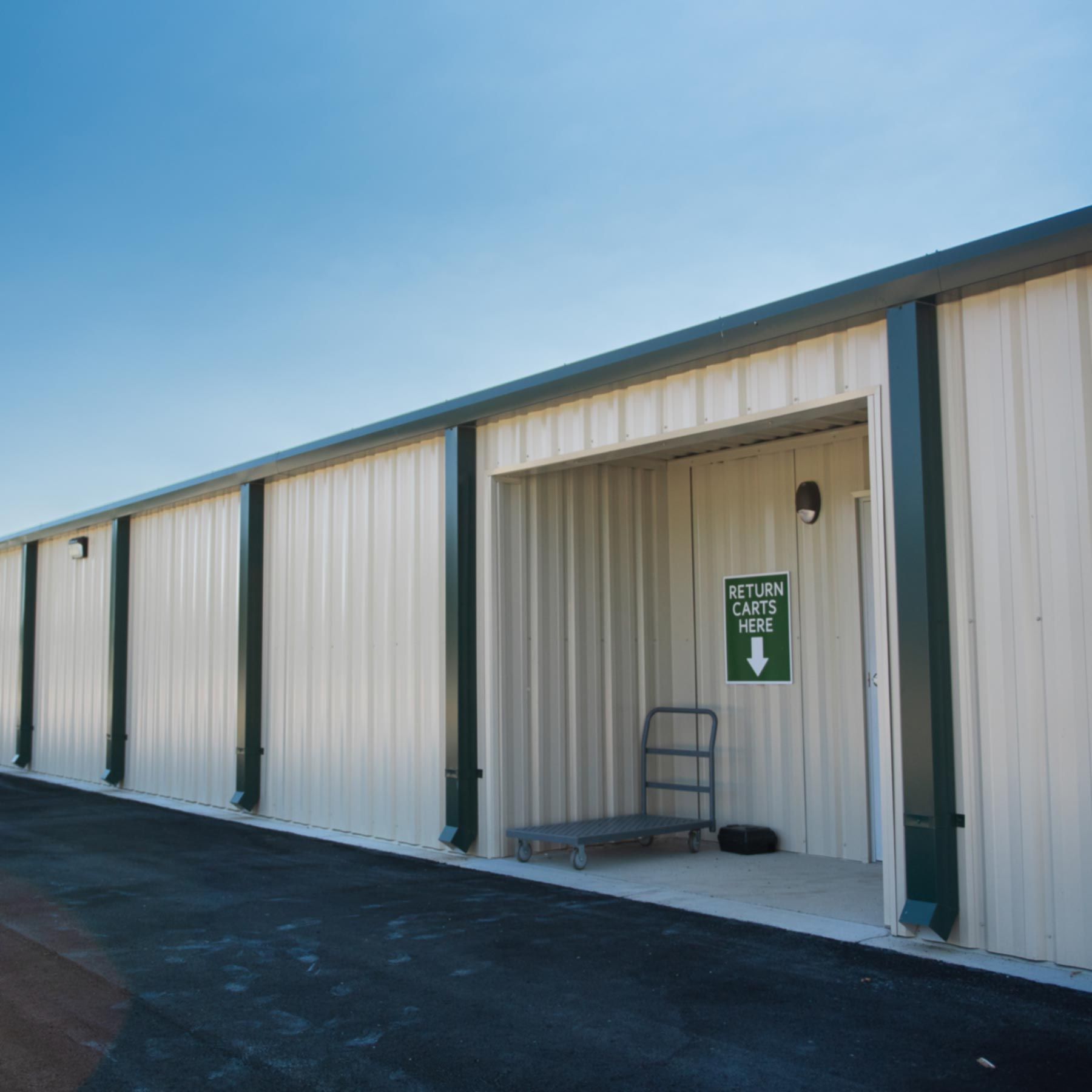 A white building with a green sign that says secure storage