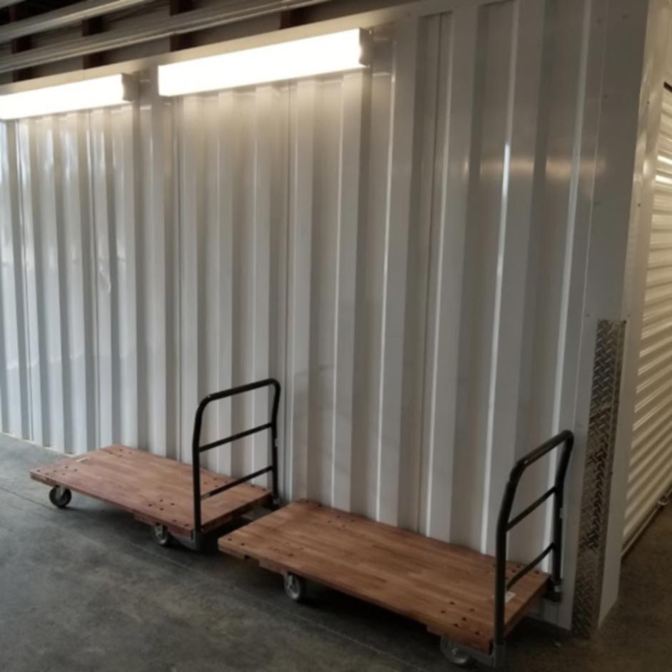 Two wooden carts in front of a white wall