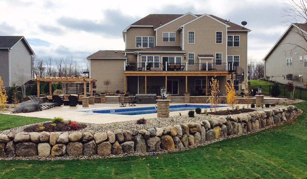 huge swimming pool with landscaping around it