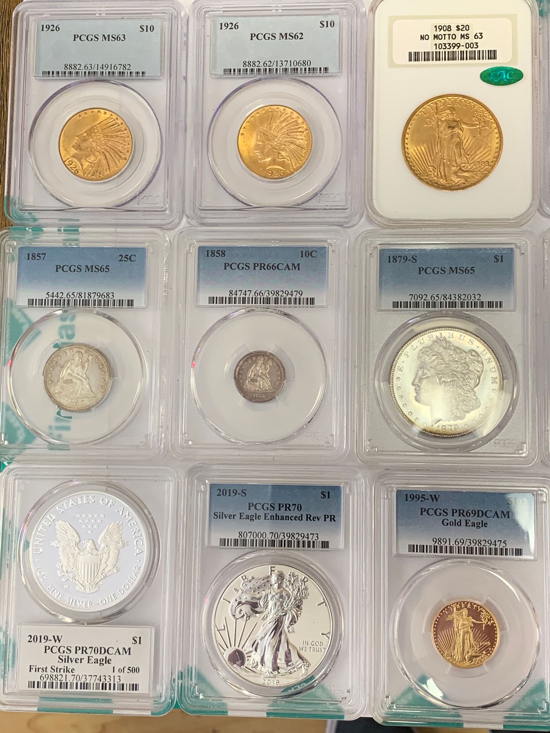 A display of nine collectible coins, each individually encapsulated in protective plastic slabs, arranged in a grid.