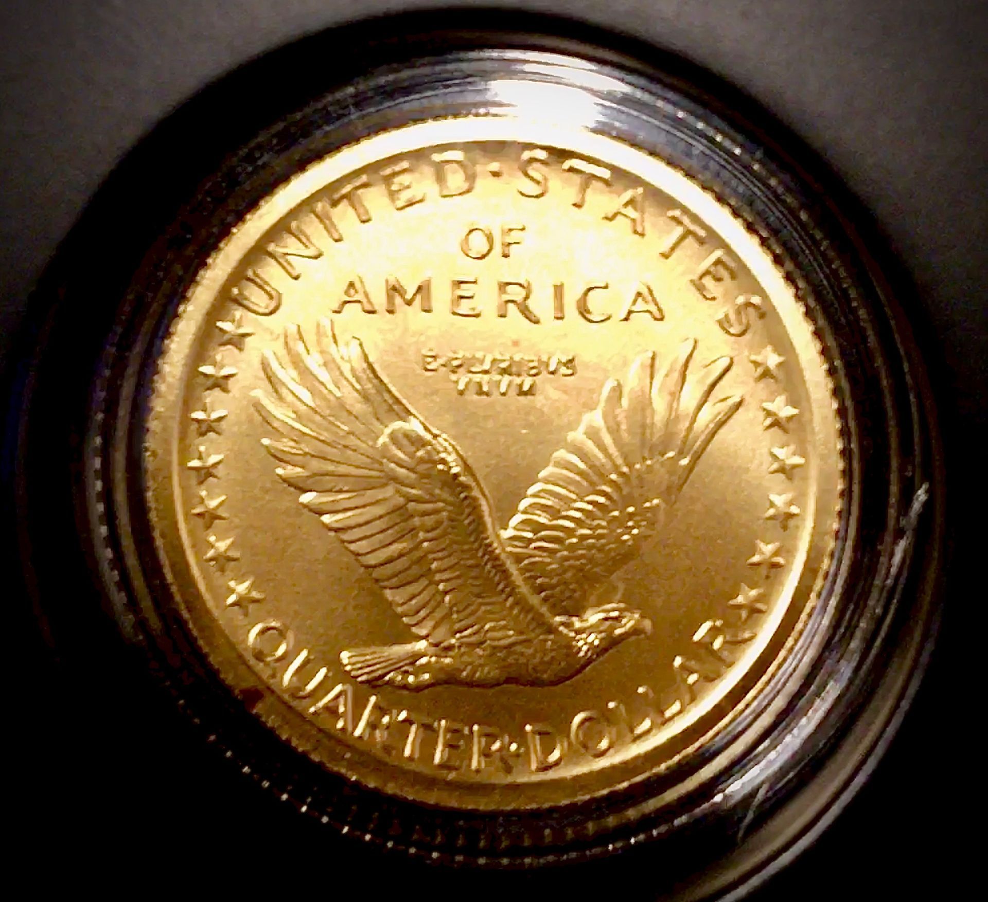 Gold-colored United States quarter dollar coin featuring an eagle in flight on the reverse side.