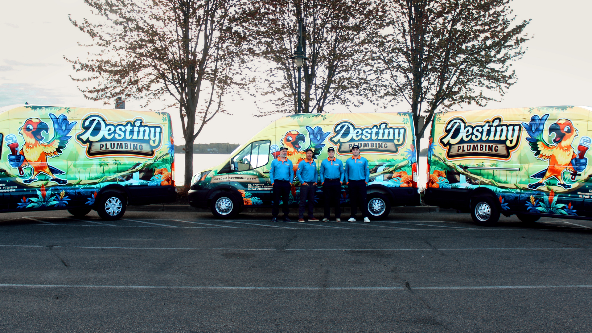 Three colorful Destiny-branded vans parked side by side with people standing in front of them.