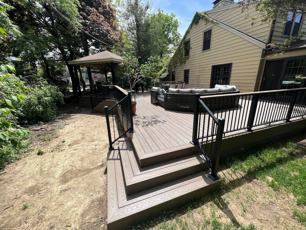 A wooden deck with stairs and a gazebo in the backyard of a house.