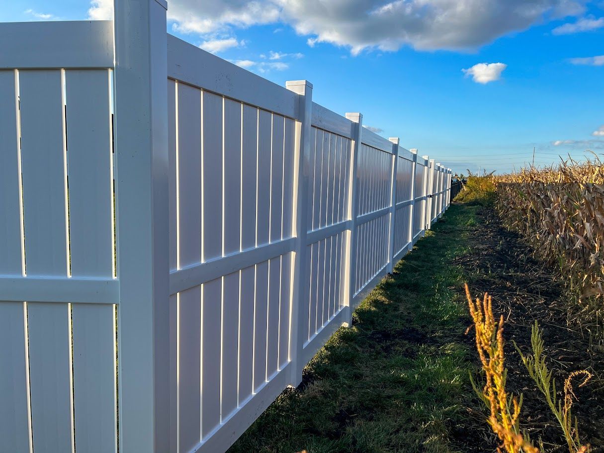 A white fence is sitting in the middle of a field.