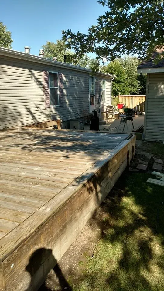 A wooden deck is being built in the backyard of a house.