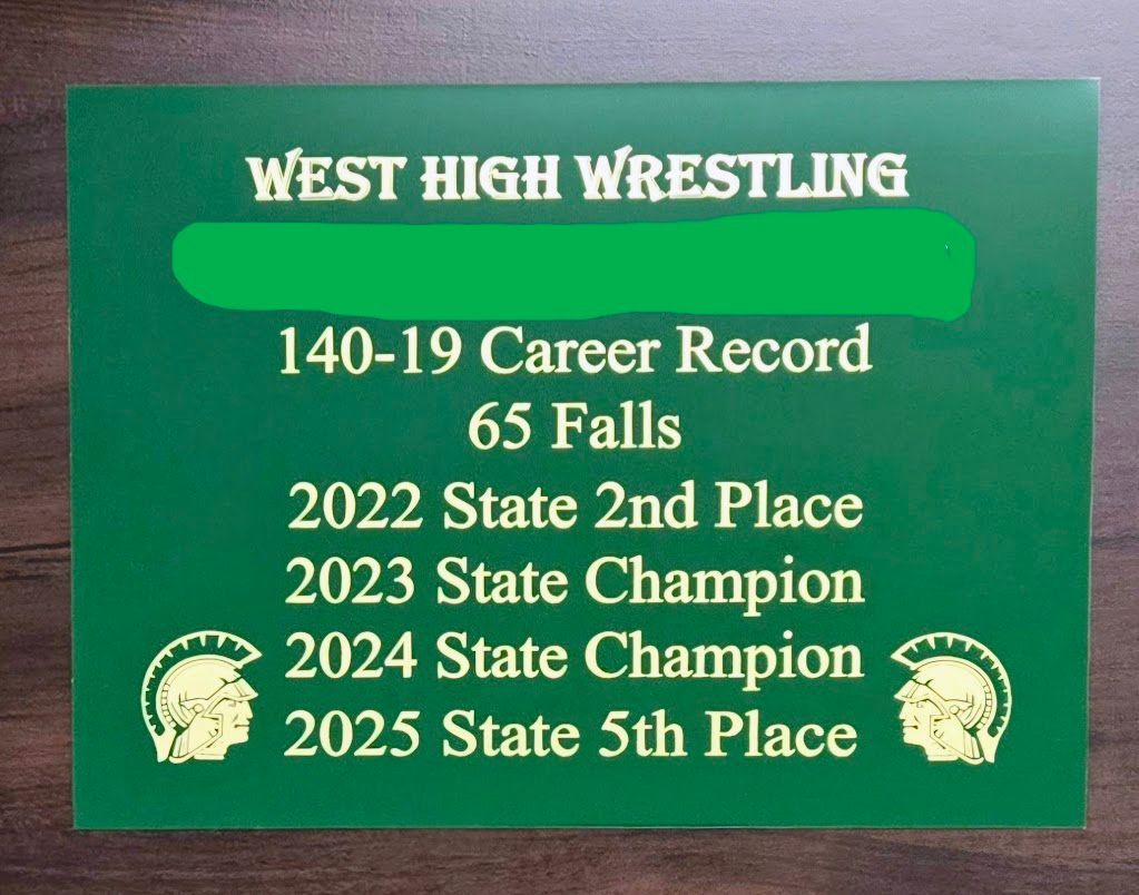 A green sign that says west high wrestling 140-19 career record 65 falls