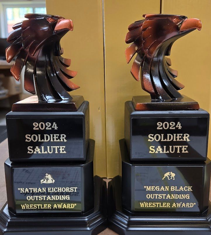 Two soldier salute trophies are stacked on top of each other