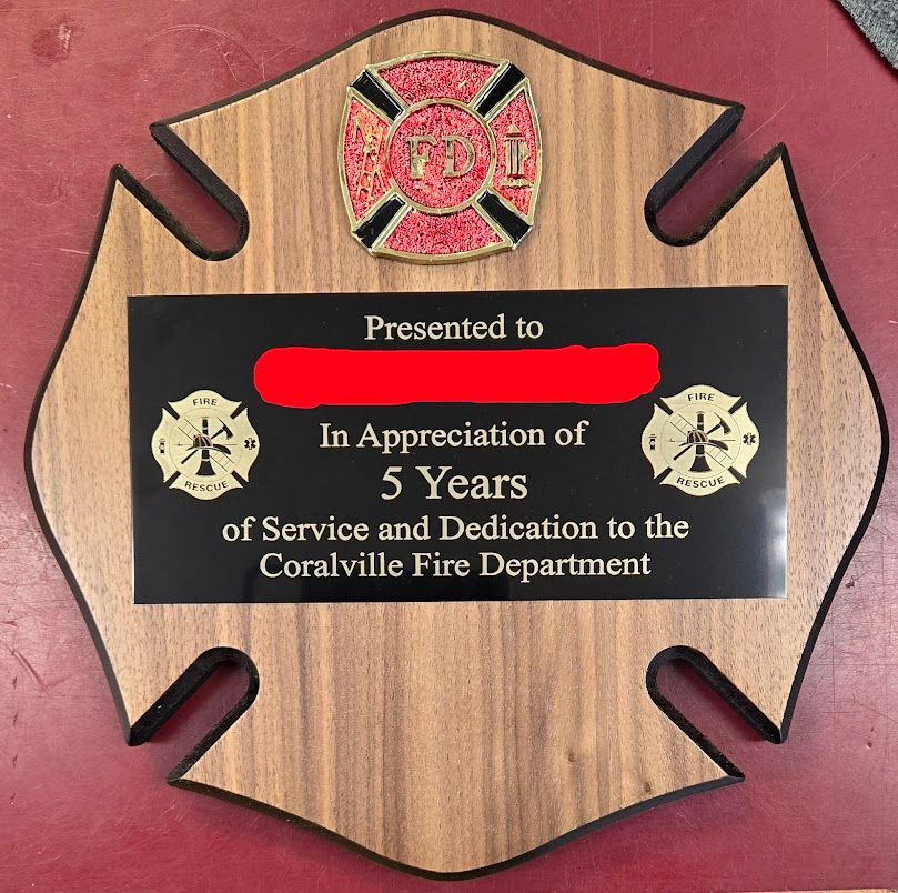 A wooden plaque that says presented to in appreciation of 5 years of service and dedication to the coralville fire department
