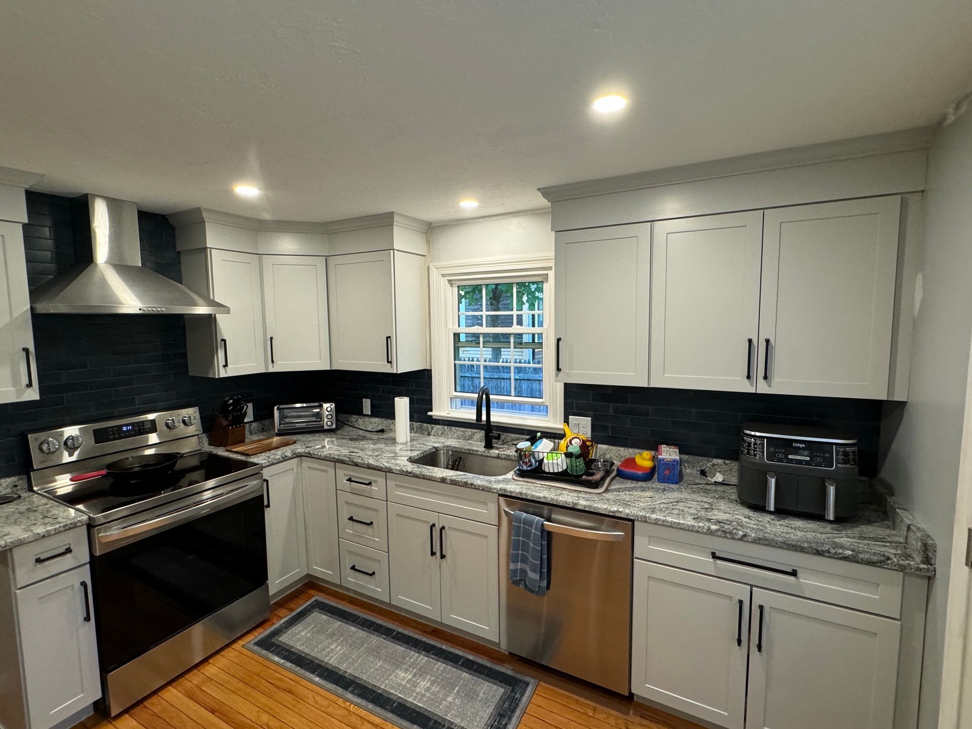 A kitchen with white cabinets and stainless steel appliances