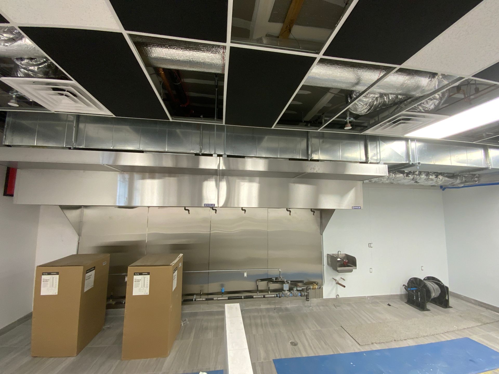 a kitchen with stainless steel appliances and boxes on the floor